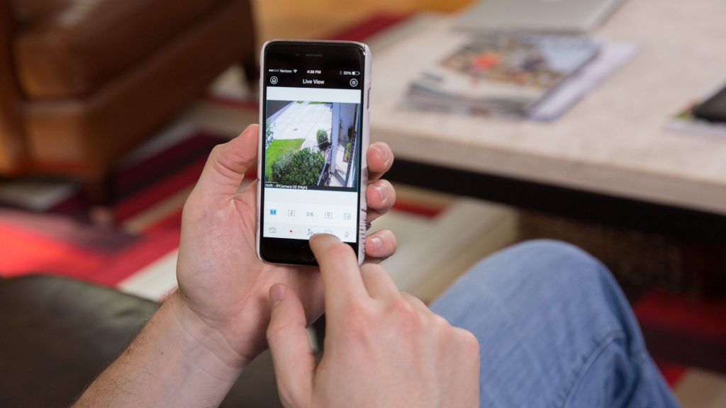 An image of a man holding a smartphone is shown, with the Control4 app interface displayed on the screen.